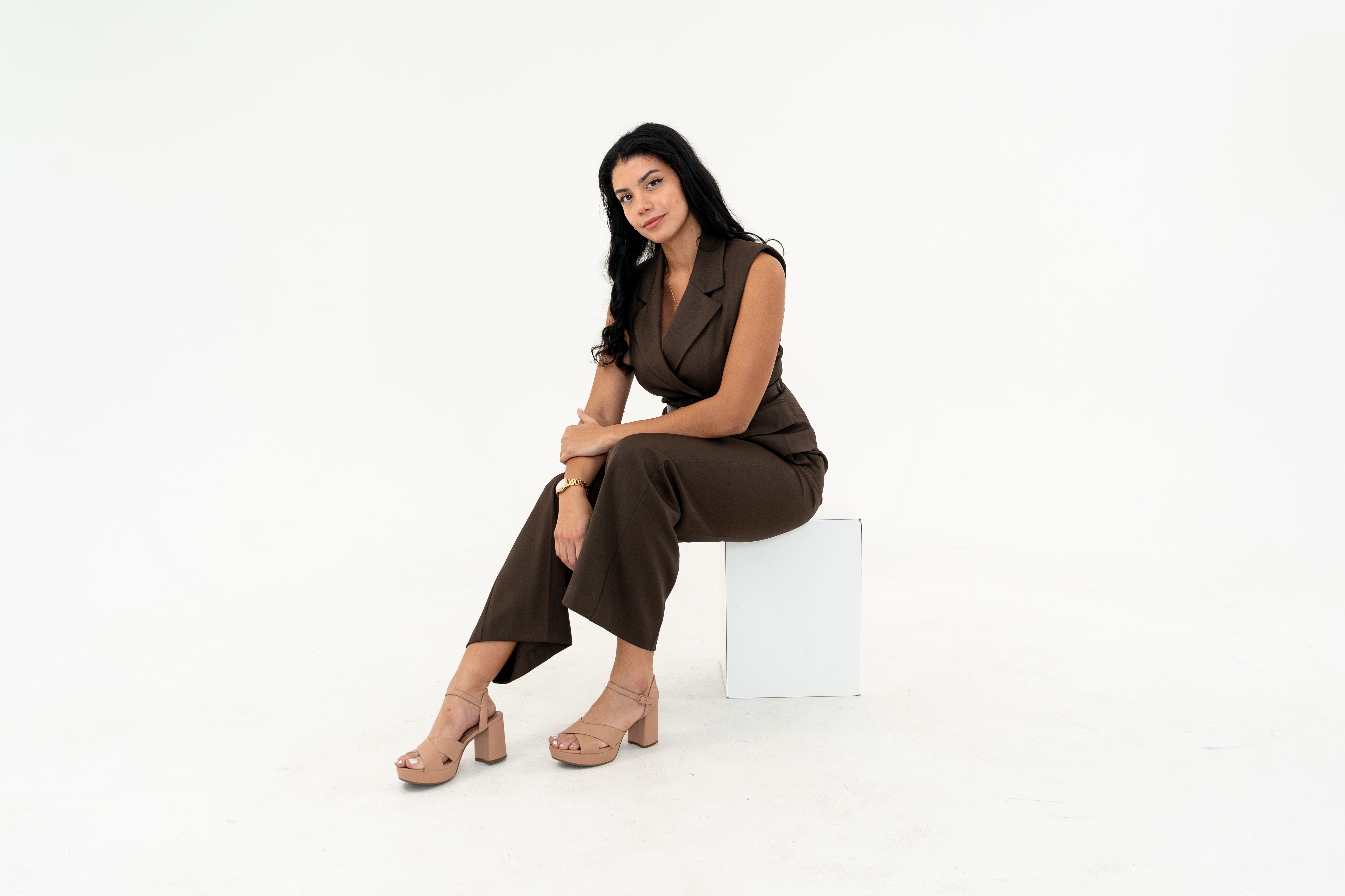 CEO, Cindy Ripoll-Martinez, sitting on a white block.